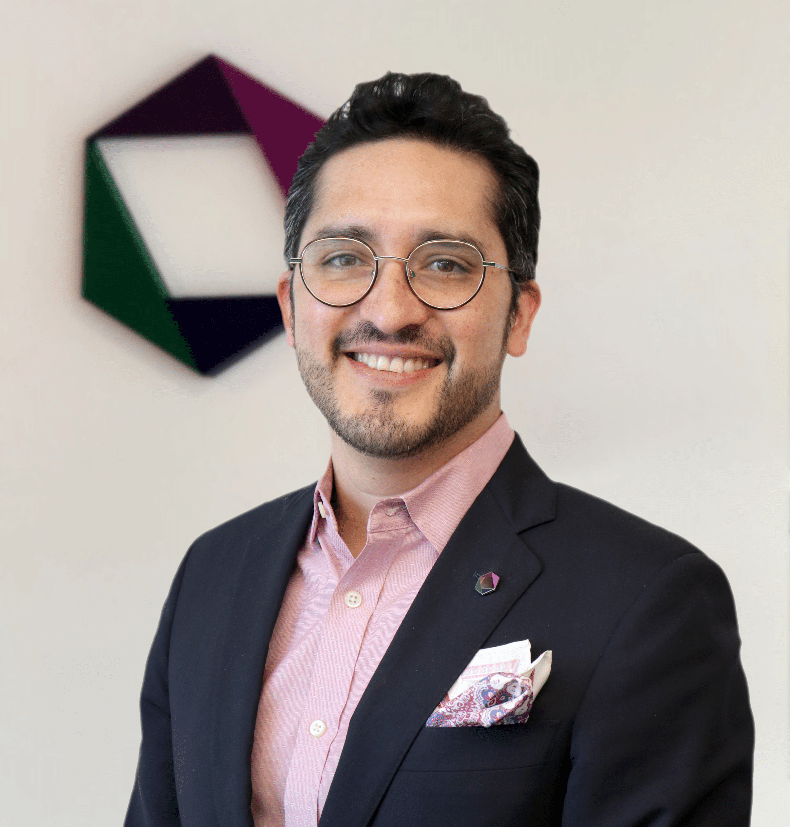 Guillermo Galdamez smiles at the camera while standing in front of the Enterprise Knowledge logo.